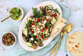 A salad with courgette, aubergine, walnuts, feta cheese and olives.