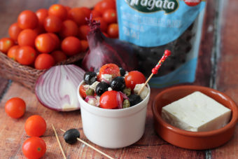 A small dish of Fragata olives with cherry tomatoes and feta cheese.